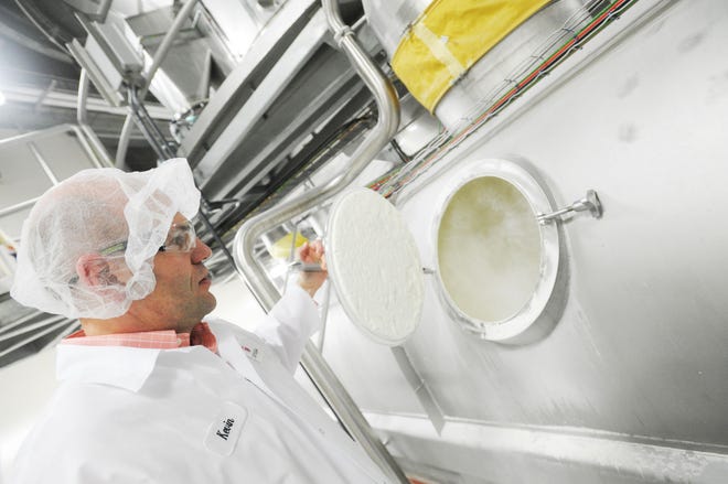 Cayuga Milk Ingredients CEO Kevin Ellis opens a container mixing powdered milk during a Jan. 22, 2015 tour of the plant.