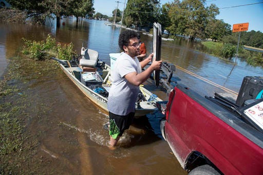 Derrick Campbell helps load equipment that he and other employees carried out on a boat from Wicked Skinsations in floodwaters caused by rain from Hurricane Matthew in Lumberton on Oct. 12. Gov. Pat McCrory says more damage is still to come for many people in the eastern part of North Carolina as the state faces its ninth day of Hurricane Matthew's aftermath. 
AP Photo/Mike Spencer