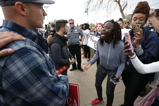 An anti-Trump protester, right, and a Trump supporter confront one another following a speech and rally with Republican presidential candidate Donald Trump, at the University of Northern Colorado, in Greeley, Colo., on Oct. 30. (AP Photo/ Brennan Linsley)
