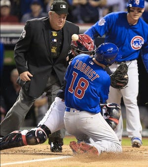 The Chicago Cubs’ Ben Zobrist runs into Cleveland Indians’ catcher Roberto Perez, dislodging the ball and scoring on an outfield error during the first inning. (Bob Rossiter/The Repository)