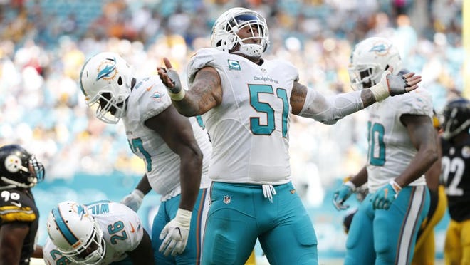 Miami Dolphins center Mike Pouncey (51) celebrates a play during the second half of an NFL football game against the Pittsburgh Steelers, Sunday, Oct. 16, 2016, in Miami Gardens, Fla. (AP Photo/Wilfredo Lee)