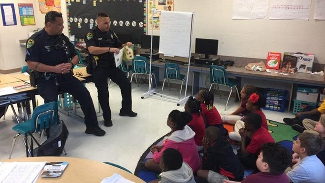 Boynton Beach Police Officers read to children for Read for the Record at Crosspointe Elementary. Photo handout: BBPD