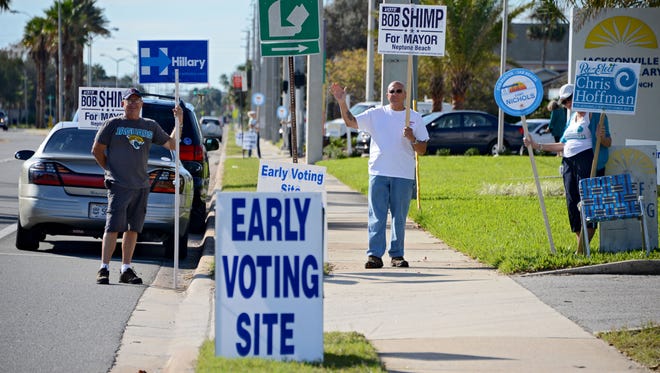 On Monday Oct. 24, 2016 campaign sign wavers, including Neptune Beach mayoral candidate Bob Shimp holding his own sign, set up outside the Early Voting site at the Beaches Branch of the Jacksonville Public Library in Neptune Beach. (Bob Mack/Florida Times-Union)