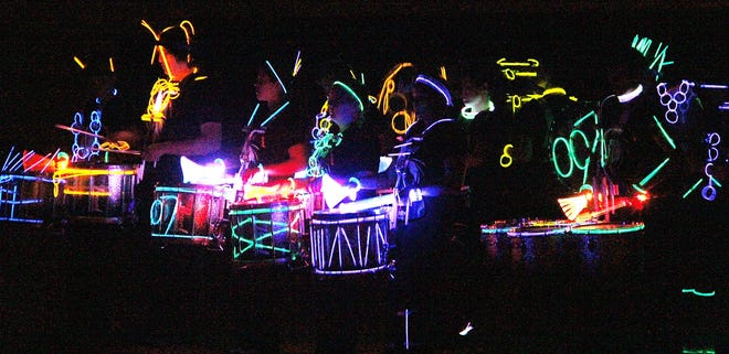 The Jonesville High School Marching 100 drumline performs during Tuesday night's glow show at the school. ANDY BARRAND PHOTO