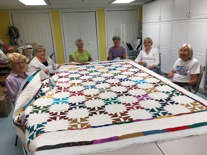 Women at Freedom Village work on a quilt. The annual bazaar is taking place this weekend. Contributed