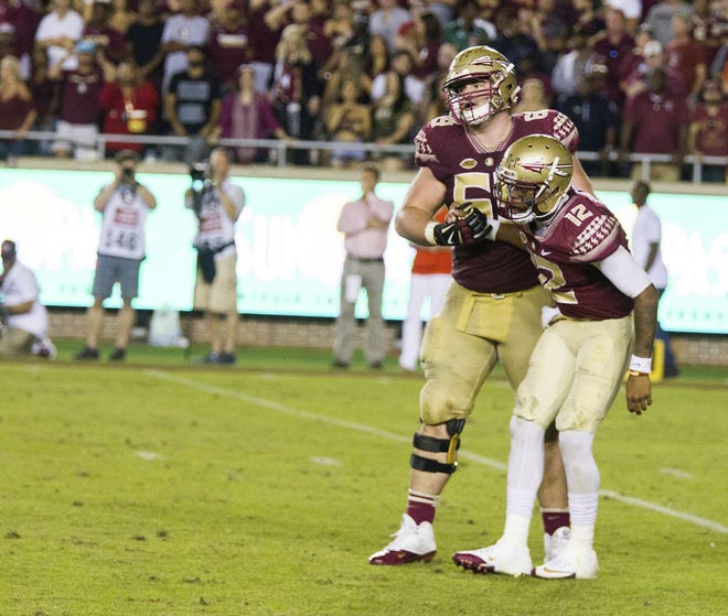 Florida State offensive lineman Landon Dickerson helps quarterback Deondre Francois up after being hit by the Clemson defense in the second half of a college football game in Tallahassee, Saturday, Oct. 29, 2016. Clemson defeated Florida State 37-34. Dickerson will miss the rest of the season with a knee injury. THE ASSOCIATED PRESS / MARK WALLHEISER