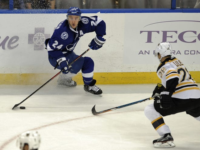 Tampa Bay Lightning right wing Ryan Callahan looks to pass under pressure from Boston Bruins defenseman John-Michael Liles during the second period of an NHL game Thursday, Nov. 3, 2016, in Tampa. THE ASSOCIATED PRESS / STEVE NESIUS