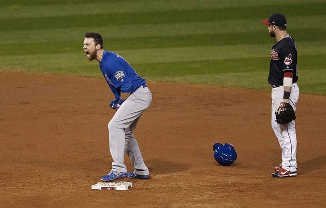 The Cubs’ Ben Zobrist cheers from second base after his double drove in a run in the 10th inning as the Indians’ Jason Kipnis stands nearby. (Jonathan Quilter/The Columbus Dispatch)