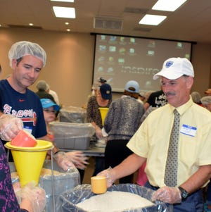 David Dixon (right) and Jeff Vanacore participated in last year's Stop Hunger Now meal packing event. Volunteers will gather again Sunday to prepare meals for disaster areas.

SUBMITTED PHOTO