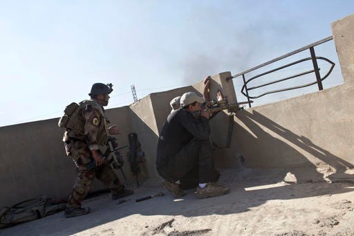 Iraqi special forces soldiers fire at Islamic State positions on the outskirts of Mosul, Iraq, Friday, Nov. 4, 2016. Heavy fighting erupted in the eastern neighborhoods of Mosul on Friday as Iraqi special forces launched an assault deeper into the urban areas of the city and swung round to attack Islamic State militants from a second entry point, to the northeast. (AP Photo/Marko Drobnjakovic)