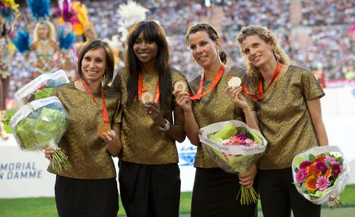 FILE - In this Sept. 9, 2016, file photo, Belgian runners, from left, Kim Gevaert, Elodie Ouedraogo, Olivia Borlee and Hanna Marien stand on the podium after receiving the gold medal for the women's 4 x 100 meter relay at the 2008 Beijing Olympics, during the Diamond League Memorial Van Damme athletics event at the King Baudouin stadium in Brussels. The Belgian team, initially winning silver, were moved up to gold after one runner on the Russian team tested positive for a banned substance. (AP Photo/Virginia Mayo)