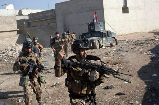 Iraqi special forces soldiers move in formation in an alley on the outskirts of Mosul, Iraq, Friday, Nov. 4, 2016. Heavy fighting erupted in the eastern neighborhoods of Mosul on Friday as Iraqi special forces launched an assault deeper into the urban areas of the city and swung round to attack Islamic State militants from a second entry point, to the northeast. (AP Photo/Marko Drobnjakovic)