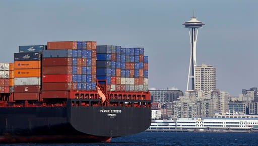 FILE - In this Feb. 15, 2015 file photo, the Space Needle towers in the background beyond a container ship anchored in Elliott Bay near downtown Seattle. The U.S. trade deficit fell in September 2016 to the lowest level in 19 months as demand for U.S.-made airplanes and other exports increased while imports slipped. The politically sensitive deficit with China declined. (AP Photo/Elaine Thompson, File)