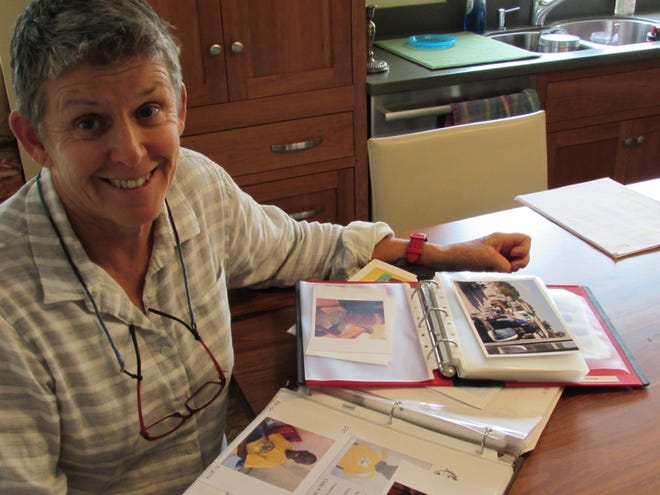 Ann Grinnell of Kittery, Maine, goes over pictures she's taken in Haiti over the years. She is holding the third annual Swim for Haiti on Nov. 19 to help raise money for children in the country. Photo by Brian Early/Seacoastonline