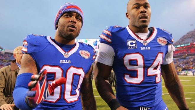 ORCHARD PARK, NY - DECEMBER 14: Bacarri Rambo #30 of the Buffalo Bills and Mario Williams #94 of the Buffalo Bills walk of the field after beating the Green Bay Packers at Ralph Wilson Stadium on December 14, 2014 in Orchard Park, New York. (Photo by Brett Carlsen/Getty Images)