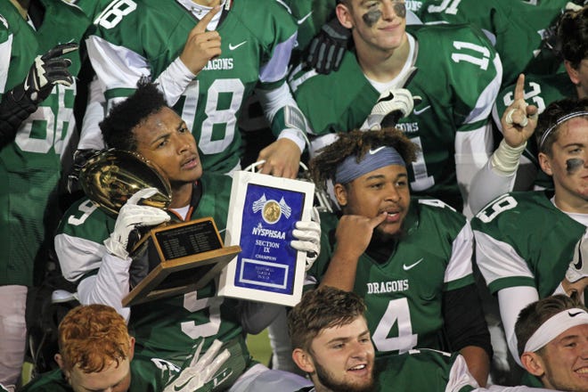 Senior defensive lineman Ryan Coles (9) holds up the Section 9 Class A trophy after Cornwall won its sixth straight sectional title by beating Goshen on Friday. WILLIAM MONTGOMERY/TIMES HERALD-RECORD
