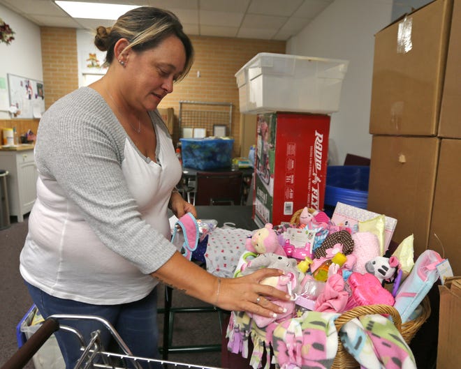 Tina Jennings arranges a Christmas gift basket for twin girls on Wednesday at Family Service Agency. PATTI BLAKE/The News Herald