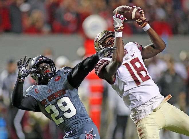 Florida State wide receiver Auden Tate (18) hauls in a pass as he is defended by North Carolina State's Jack Tocho (29) during the first half in Raleigh, N.C., Saturday. THE ASSOCIATED PRESS / KARL B. DEBLAKER