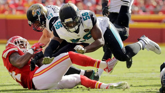 Kansas City Chiefs running back Knile Davis (34) is tackled by Jacksonville Jaguars defensive end Dante Fowler (56) and linebacker Paul Posluszny (51) during the first half of Sunday’s game. (AP Photo/Charlie Riedel)