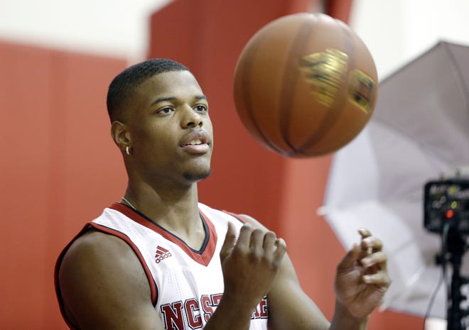 FILE - In this Sept. 29, 2016, file photo, North Carolina State's Dennis Smith Jr. tosses a ball while being photographed during the NCAA college basketball team's media day in Raleigh, N.C. Smith enrolled early in January to focus on recovering from a serious knee injury suffered before his senior year of high school. (AP Photo/Gerry Broome, File)