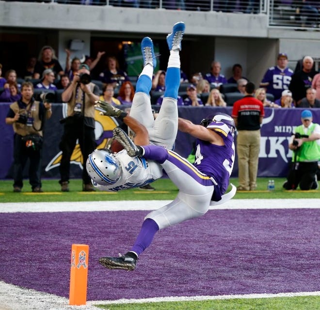 Detroit Lions wide receiver Golden Tate (15) flips into the end zone in front of Minnesota Vikings strong safety Andrew Sendejo, right, after catching a 28-yard touchdown pass during overtime in an NFL football game Sunday, Nov. 6, 2016, in Minneapolis. The Lions won 22-16.