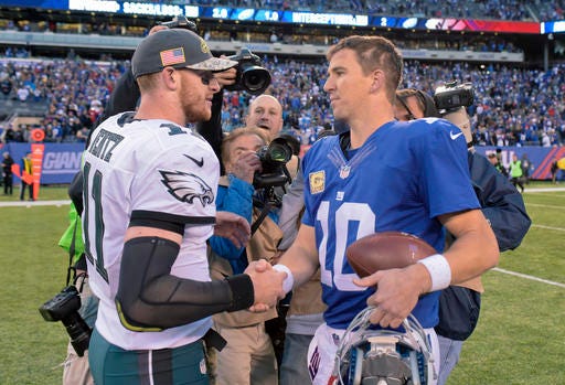 Philadelphia Eagles quarterback Carson Wentz (11) shakes hands with New York Giants quarterback Eli Manning (10) =after the Giants beat the Philadelphia Eagles 28-23 in an NFL football game, Sunday, Nov. 6, 2016, in East Rutherford, N.J. (AP Photo/Bill Kostroun)
