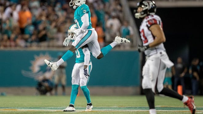 Miami Dolphins strong safety Reshad Jones (20) and Miami Dolphins defensive back Byron Maxwell (41) celebrate an interception by Jones at Camping World Stadium in Orlando, Florida on August 25, 2016. (Allen Eyestone / The Palm Beach Post)