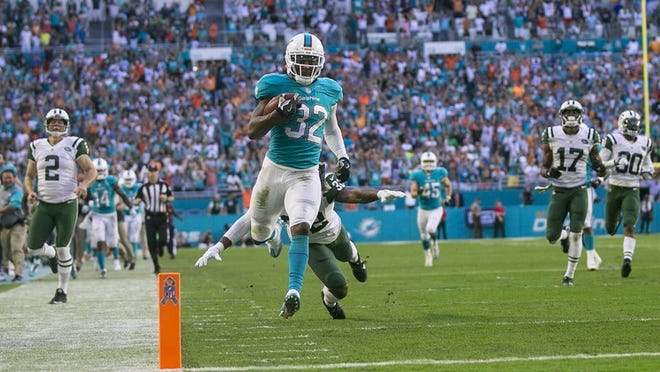 Miami Dolphins running back Kenyan Drake (32), runs away from Jets defenders on his way to a kickoff return touchdown late in the fourth quarter of their NFL game Sunday November 06, 2016 at Hard Rock Stadium in Miami Gardens. (Bill Ingram / The Palm Beach Post)