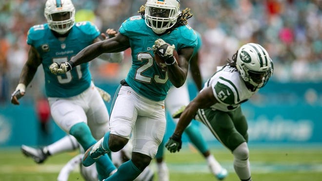 Miami Dolphins running back Jay Ajayi (23), runs away from New York Jets outside linebacker Julian Stanford (51), on his way to scoring the Dolphins first touchdown against the New York Jets during first quarter action of their NFL game Sunday November 06, 2016 at Hard Rock Stadium in Miami Gardens. (Bill Ingram / The Palm Beach Post)