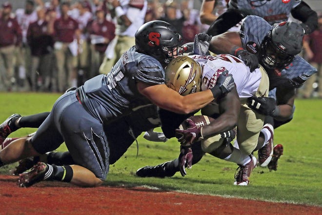 Florida State running back Jacques Patrick (9) drives into the end zone for a touchdown through the tackle of North Carolina State's Ford Howell (44) and Dravious Wright, right, during Saturday's college football game in Raleigh, N.C. AP PHOTO / KARL B. DEBLAKER