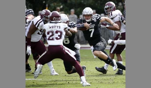 Mississippi State quarterback Nick Fitzgerald (7) runs at Texas A&M defensive back Armani Watts (23) and other defenders Saturday,

(Rogelio V. Sanders/AP)