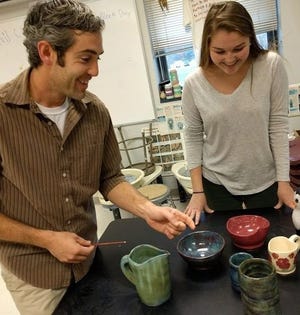 Marshwood High School art instructor Jeff Vinciguerra and senior Sarah MacDonald examine some of the ceramic pots she will exhibit at the SoBoArts Holiday Show in South Berwick, her first commercial venture as an artist.