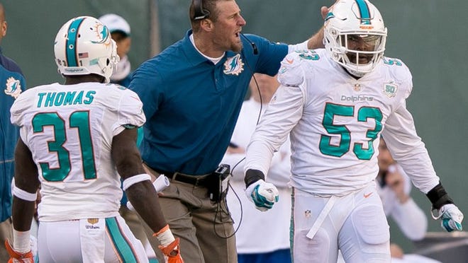 Miami Dolphins interim head coach Dan Campbell congratulates Miami Dolphins outside linebacker Jelani Jenkins (53) for defending a fourth down play at MetLife Stadium in East Rutherford, New Jersey on November 29, 2015. (Allen Eyestone / The Palm Beach Post)