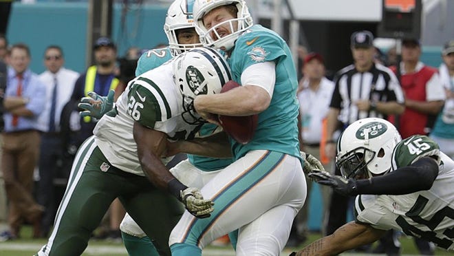New York Jets running back Troymaine Pope (26) and New York Jets strong safety Rontez Miles (45) tackle Miami Dolphins punter Matt Darr (4) during the second half of an NFL football game, Sunday, Nov. 6, 2016, in Miami Gardens, Fla. Darr dropped the ball. (AP Photo/Lynne Sladky)