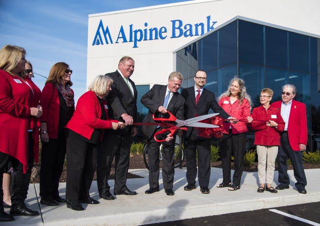 Alpine Bank Chairman Rob Funderburg Jr. cuts the ribbon during the grand opening of the bank's newest location on North Main Street on Nov. 7, 2016, alongside Rockford Chamber of Commerce President Einar Forsman and Mayor Larry Morrissey. KAYLI PLOTNER/STAFF PHOTOGRAPHER/RRSTAR.COM