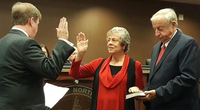 Donna Aaron takes the oath of office from Judge Jim Gentry while her husband, Sonny, holds the Bible on Monday night at Northport City Hall. Staff photo/Stephen Dethrage