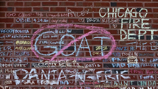 Messages in support of the Cubs' championship run and in remembrance of friends and family who never saw the Cubs win the World Series, are written and drawn in chalk on an outer wall at Wrigley Field. THE ASSOCIATED PRESS