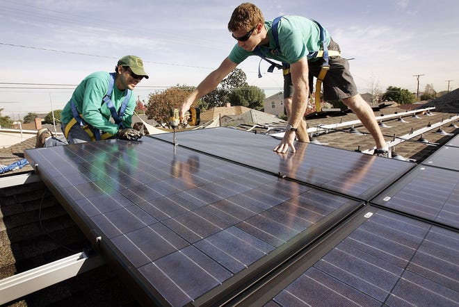 Joey Ramirez, left, and Taran Stone with SolarCity install solar modules on the roof of a Long Beach, Calif., home. Florida "has a ton of sunshine, a ton of rooftops," a SolarCity spokesman said. "But there is no rooftop solar industry in Florida." (Al Seib/Los Angeles Times/MCT)