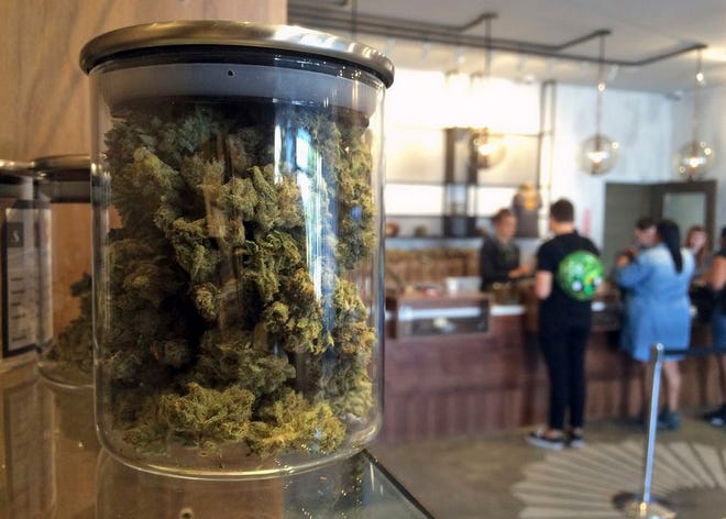 In this April 20, 2016 file photo, customers buy products at the Harvest Medical Marijuana Dispensary in San Francisco. California's lopsided U.S. Senate is nearing a historic end and voters are pondering a long list of ballot questions that could legalize marijuana, end the death penalty and slap cigarette smokers with a $2-a-pack tax increase.