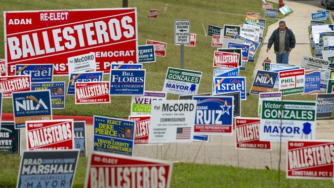 A voter walks among campaign signs on Election Day