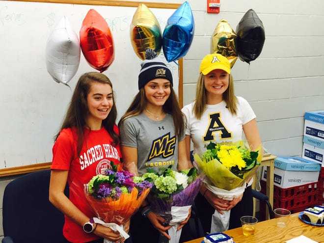 Winnacunnet High School seniors, from left, Kelly Arsenault, Meg Dzialo and Abby Merrill, signed their National Letters of Intent on Wednesday at a ceremony at the school. Jay Pinsonnault/Seacoastonline