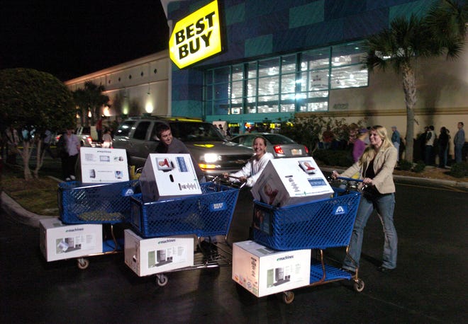 Joe Clark, from left, Courtney Dietch and Kimberly Andrews arrived at Best Buy at 10 p.m. Thanksgiving Day 2005 to be there for its opening at 5 a.m. Black Friday. This year, Best Buy is likely to start the doorbuster sales on the holiday. HERALD-TRIBUNE ARCHIVE / 2005