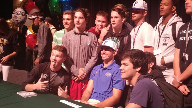 Lakewood Ranch High's Colton Zimring, middle sitting with a baseball hat, celebrates signing with the University of Florida with his classmates. Zimring, a pitcher/first baseman for the Mustangs signed his National Letter of Intent Wednesday. Herald-Tribune photo / John Lembo