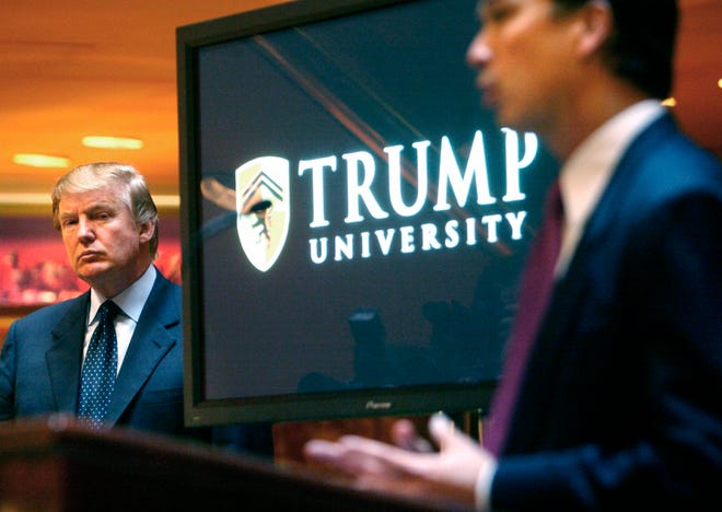 FILE- In this May 23, 2005 file photo, then real estate mogul and Reality TV star Donald Trump, left, listens as Michael Sexton introduces him at a news conference in New York where he announced the establishment of Trump University. Trump is scheduled to go on trial this month in a class-action lawsuit against him and his now-defunct Trump University, potentially taking the witness stand weeks before his inauguration as president of the United States. U.S. District Judge Gonzalo Curiel, the Indiana-born jurist who was accused of bias by Trump during the campaign for his Mexican heritage, will hold a hearing Thursday, Nov. 10, 2016, on jury instructions and what evidence to allow at trial. (AP Photo/Bebeto Matthews, File)