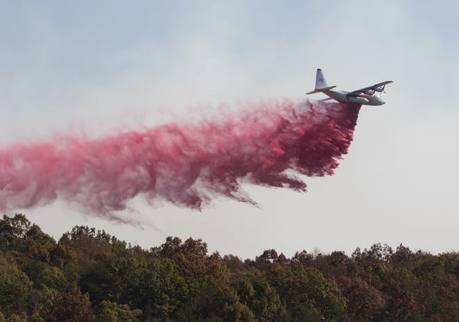 An aircraft from the US Forestry Service drops fire retardant on a wildfire burning along the Flipper Bend area of Signal Mountain in Hamilton County, Tenn., on Wednesday, Nov. 9, 2016. Wildfires burning across the South have created a smoky haze over metro Atlanta and prompted a public health advisory in Kentucky, and the forests are expected to continue burning for days as flaming leaves fall to the ground and spread the flames. Other fires were burning in parts of Alabama, North Carolina and Tennessee. (Dan Henry/The Chattanooga Times Free Press via AP)
