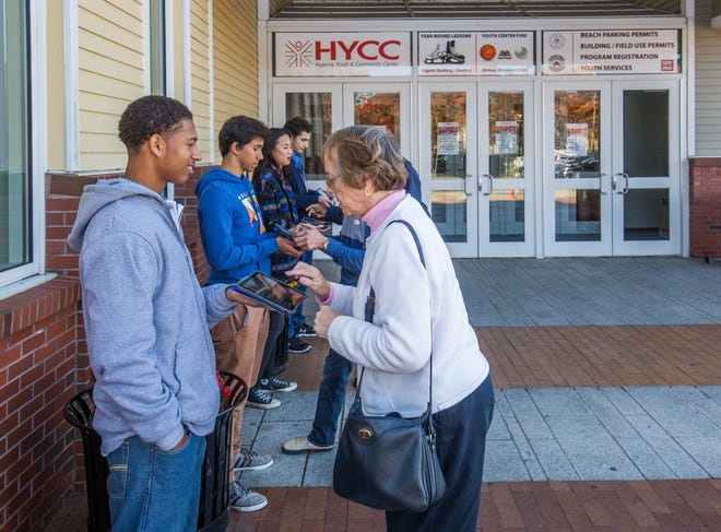 Makhai Pells from Steve Moynihan's AP U.S. Government and Politics class conducts an exit poll with Marianna Moseley outside the Hyannis Youth and Community Center. The other students are Lucas Lanzo, Olivia Price and Justyn Moore. PHOTO BY ALAN BELANICH