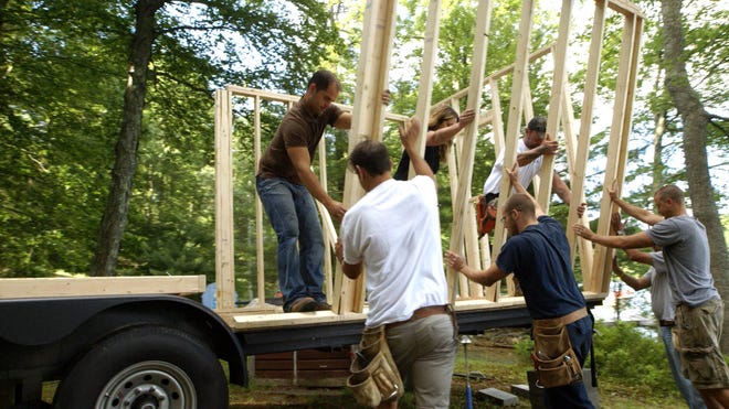 The 'Sharing Paradise' construction crew raises the wall of a tiny home during the filming of an episode in Hawley. (Photo provided)