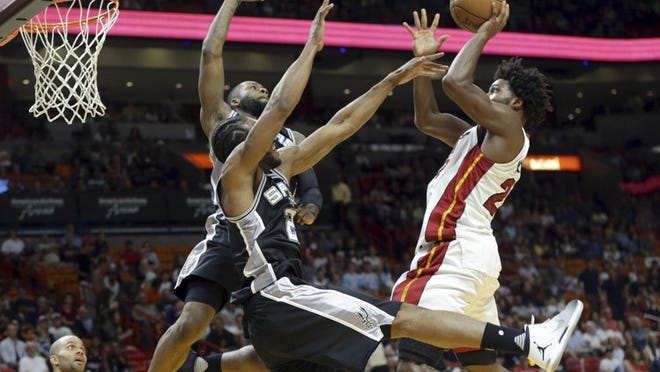 Miami Heat's Justise Winslow, right, goes to the basket as San Antonio Spurs' Jonathon Simmons, left, and Kawhi Leonard (2) defend during the first half of an NBA basketball game, Sunday, Oct. 30, 2016, in Miami. (AP Photo/Lynne Sladky)