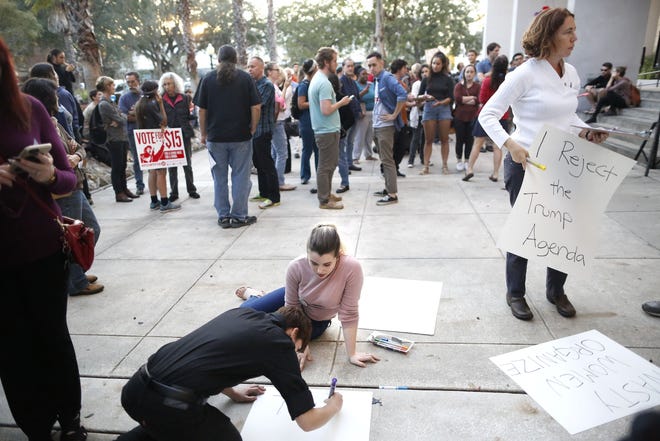 Protesters make signs to hold during a speak out about the election results at City Hall in Gainesville Thursday. (Brad McClenny/Staff Photographer)