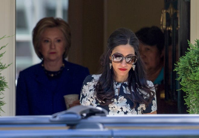 FILE PHOTO: In this June 10, 2016, photo, top Clinton aide Huma Abedin walks ahead of Democratic presidential candidate Hillary Clinton following a private meeting at Clinton's home in Washington. Clinton and Abedin discussed sending a secure cell phone to the secretary of state by FedEx or a personal courier, according to emails released on Nov. 3, 2016. The State Department said either approach would have been acceptable, if the telephone was rendered inoperable for the journey.